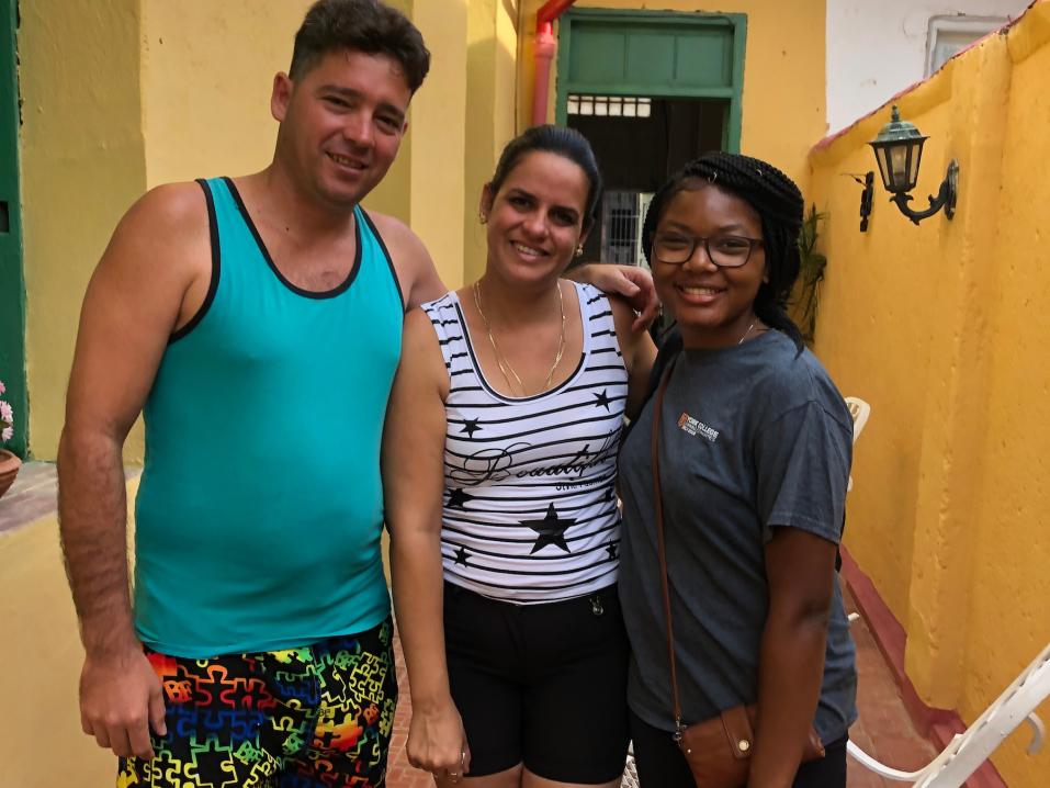 A study abroad student in Cuba with two locals