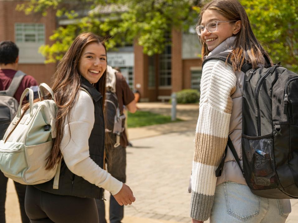 students wearing backpacks and smiling