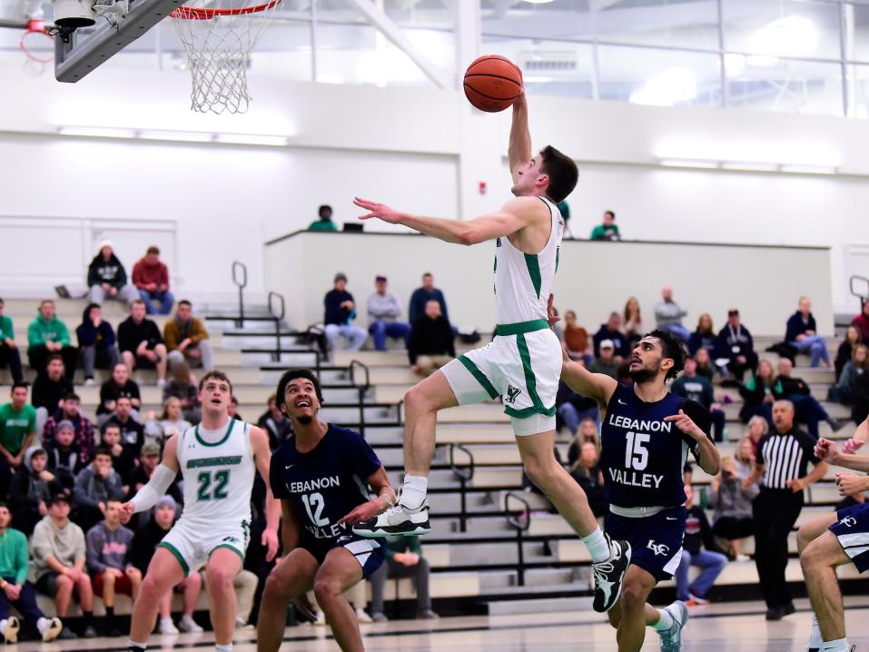 A York College Men's Basketball player going up for a layup during a game.
