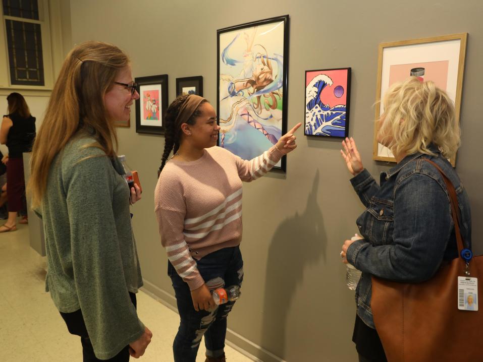 York-area high school student showing their artwork to community members during the YCASE Art Walk.
