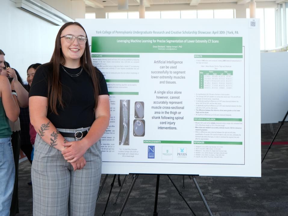 Grace Strickland stands next to her Undergraduate Research Showcase presentation