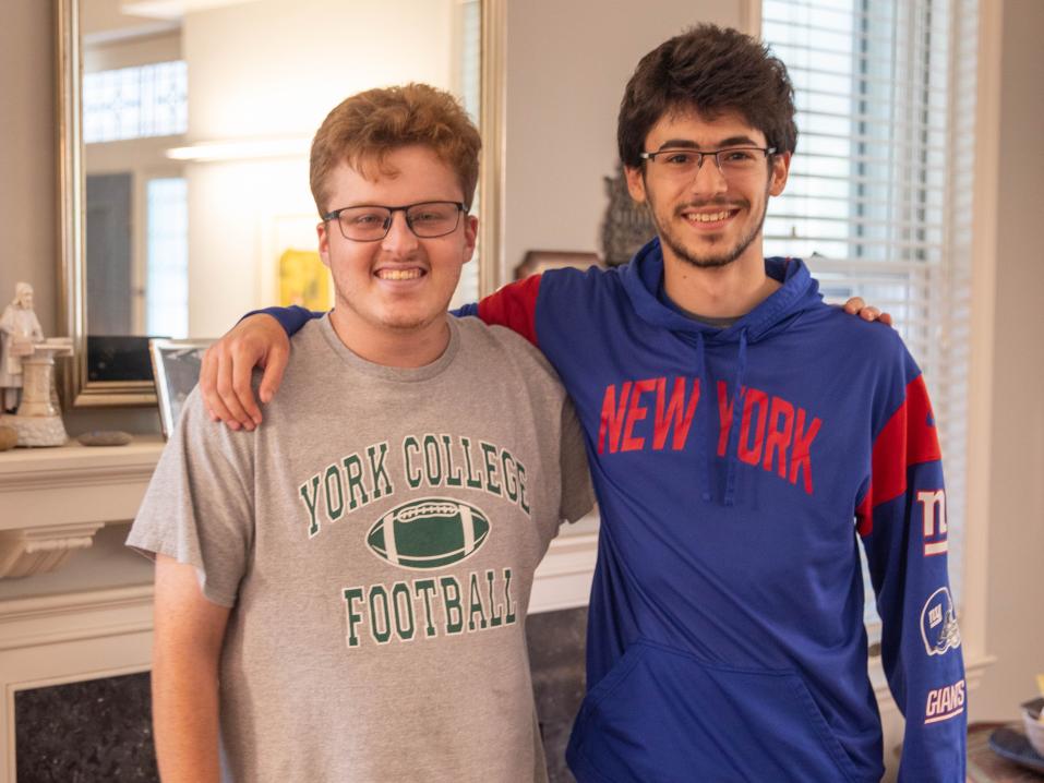 Two students stand together facing the camera smiling