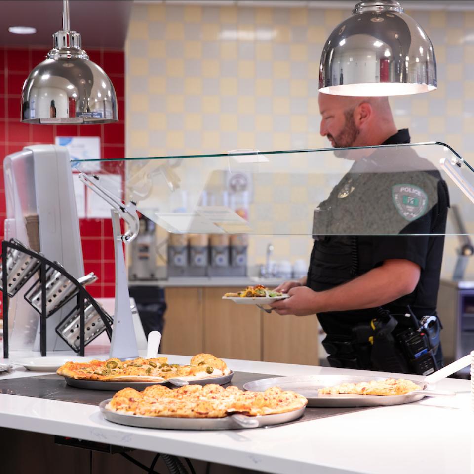 A chef works behind the pizza buffet station at the West Campus Dining Hall.