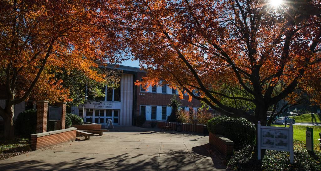 An exterior view of the Iosue Student Union building, surrounded by colorful fall foliage.
