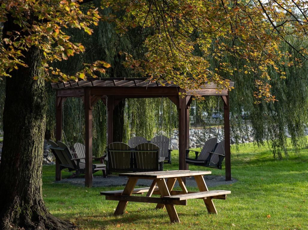 A picnic table by the set of swings along the campus creek.