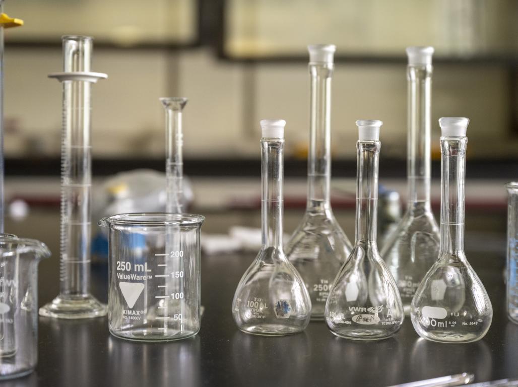 Beakers of varying sizes are on a counter in a chemistry lab.