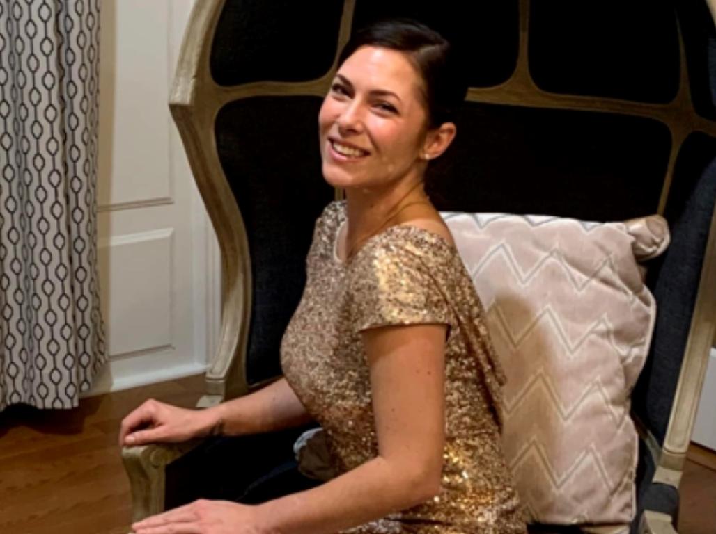 Ashley Crist seated on a padded chair in her home.