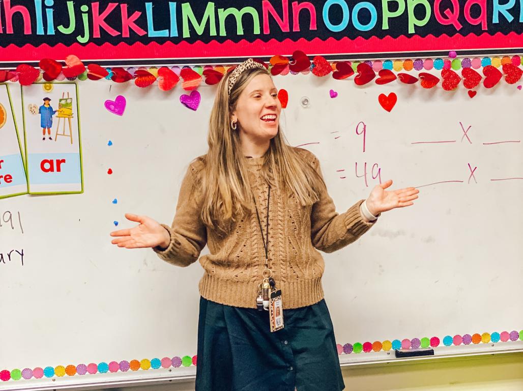 Brianna Weaver stands in front of her elementary school classroom.