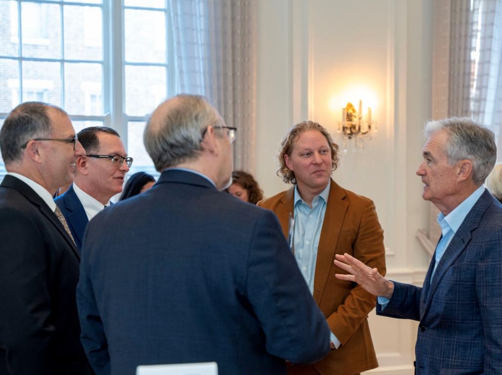 York College President Dr. Thomas Burns stands with local businessmen, Patrick Harker, head of the Federal Reserve Bank of Philadelphia, and Federal Reserve Chair, Jerome Powell. Mr. Powell gestures with his hand as he speaks to the group.