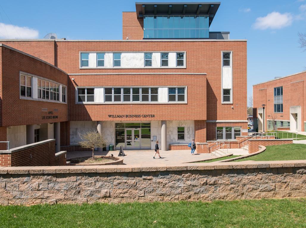 Exterior photo of the Graham School of Business and the Appell Life Sciences Center, students are walking to class in front of the buildings.