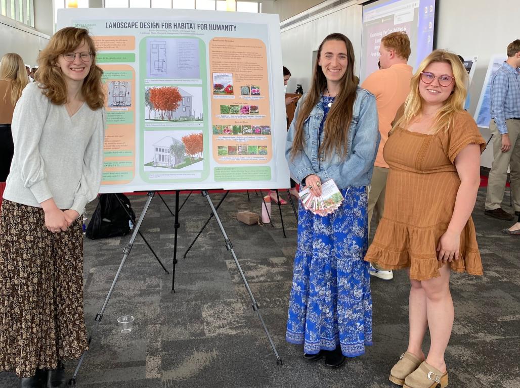 3 students presenting their research at a research showcase.