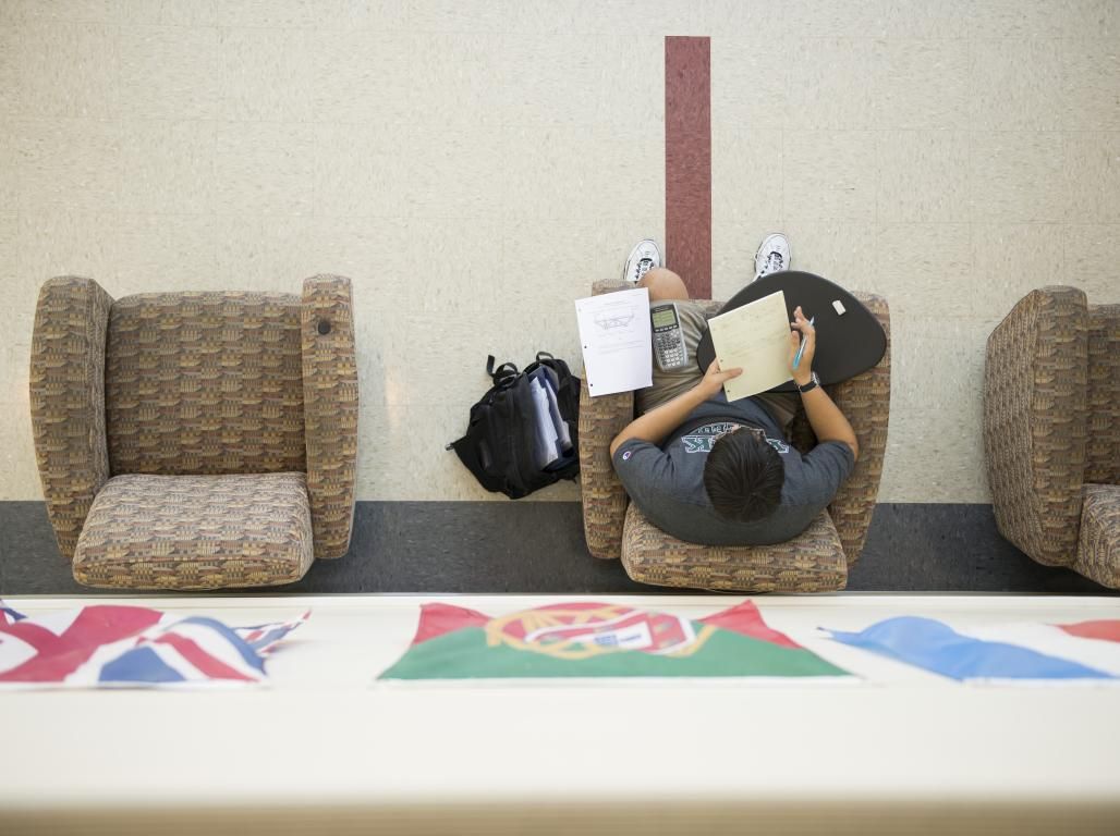 A student is studying in the Humanities building back lobby