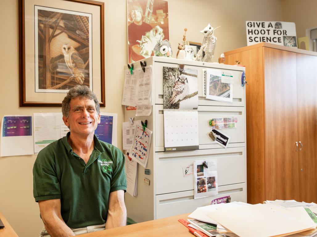 Karl Kleiner, Associate Professor of Biology, seated at his office desk. 