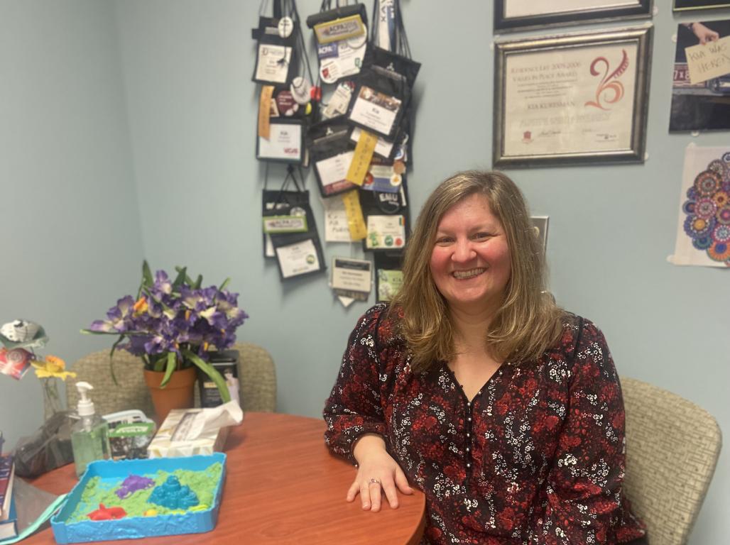 Kia sitting in her office smiling at the photo.