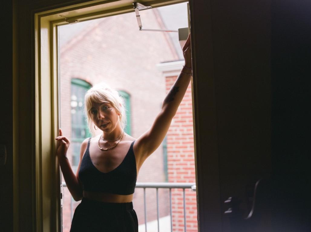 Lizz Dawson leading on a wall in a window frame.