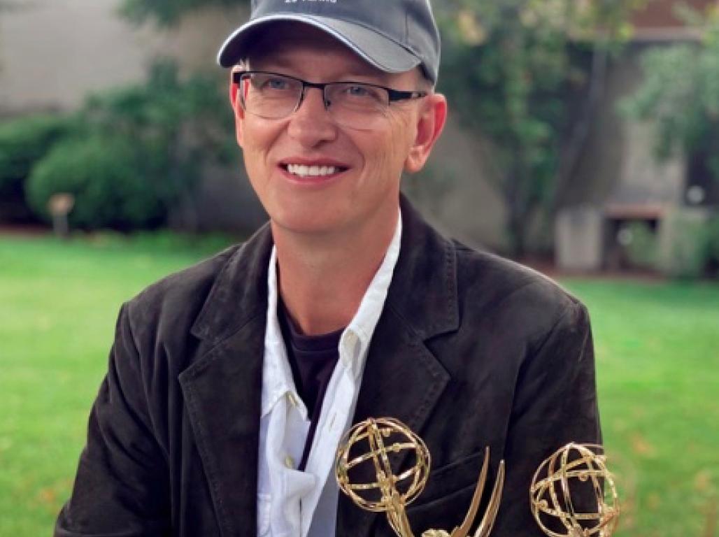 Todd Ballantyne seated at a table with two Emmy awards in front of him.