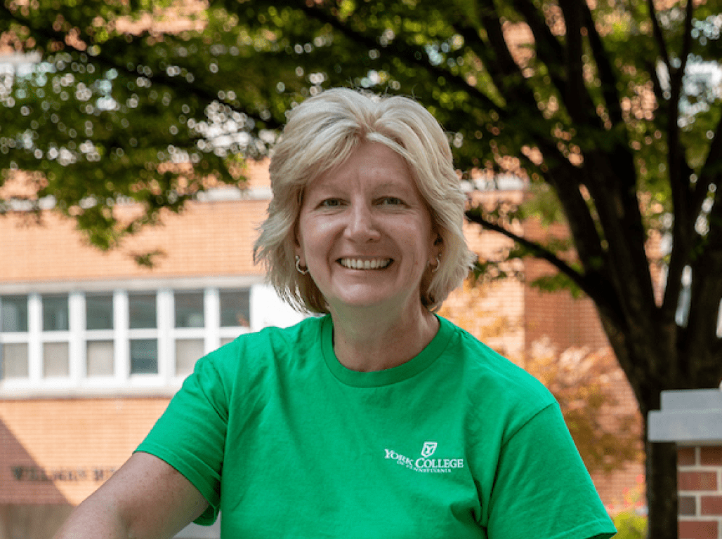 Lisa Layden sits by the fountain and smiles while posing for a photo