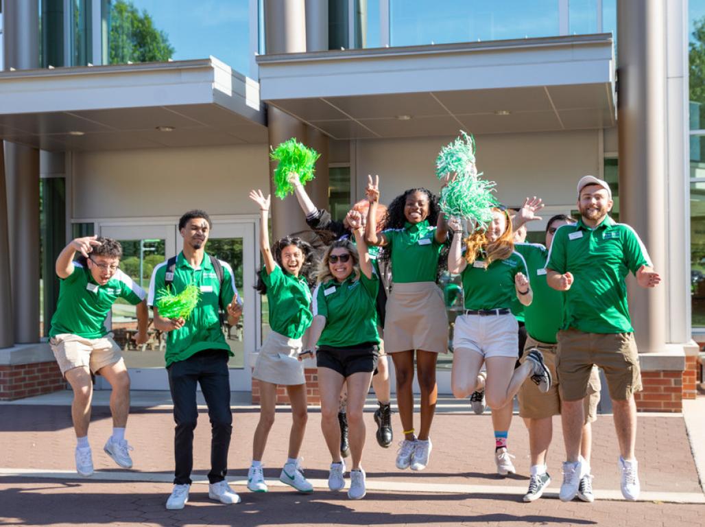 A group of York College students wearing green and cheering.