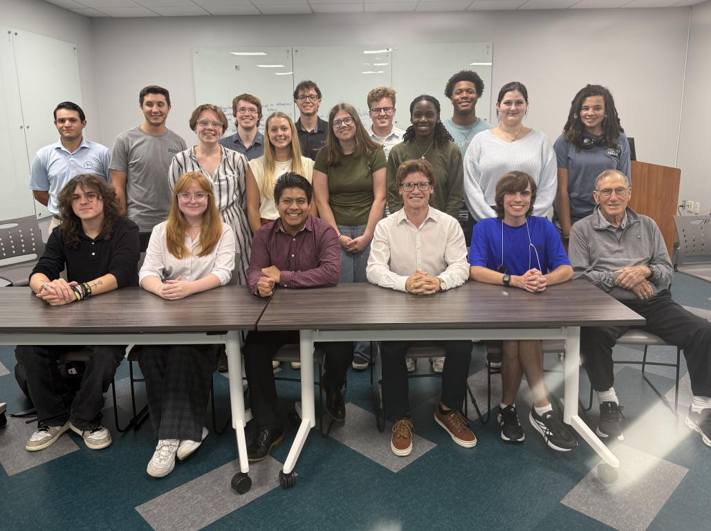 Don Graham poses for a photo with a large group of students
