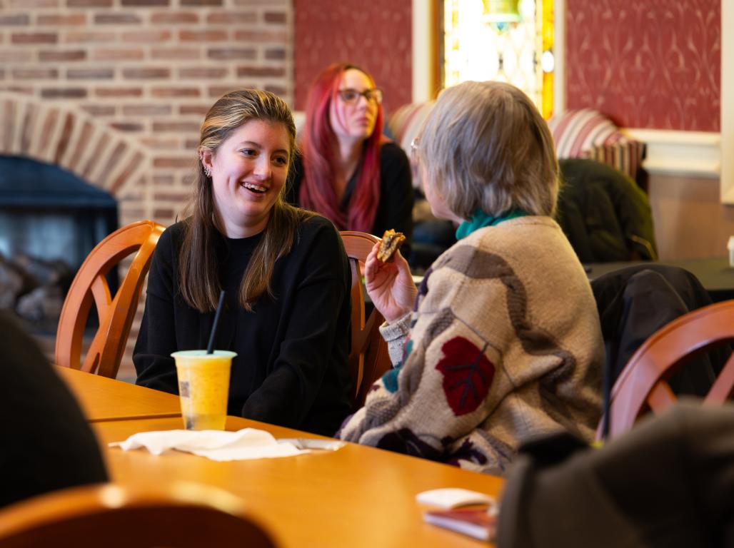 Two women talk together in Founders Hall