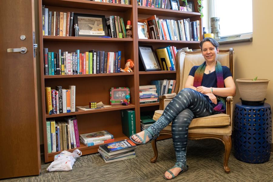 Randi Shedlosky-Shoemaker, sitting by a bookcase in her office.