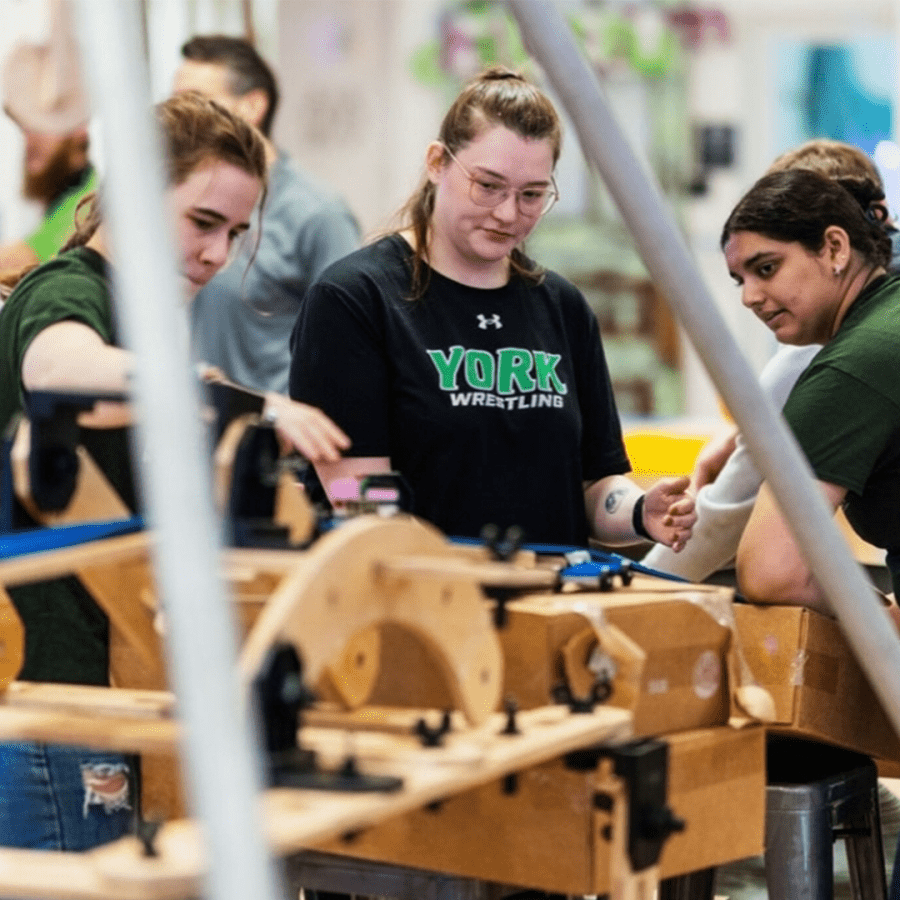 Three engineering students engaged in a hands-on project.