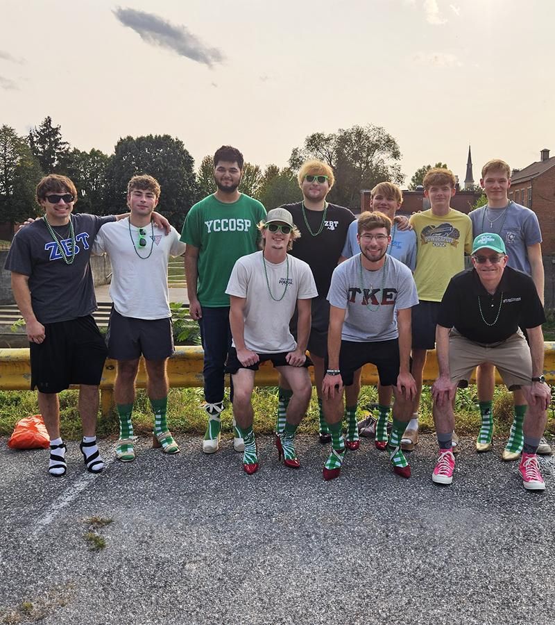 Dr. Burns poses for a photo for the Walk a Mile in Her shoes event with students