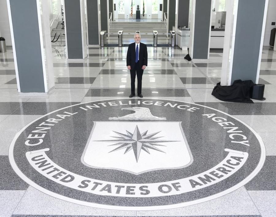 Darryl D. Bowman standing in the CIA building with the CIA seal design on the floor.