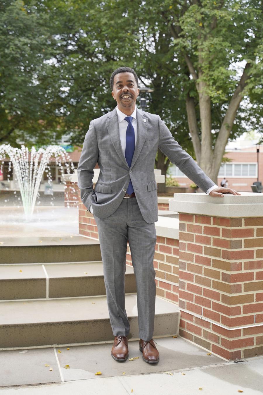 York College CFO Michael Doweary stands with the campus fountain behind him