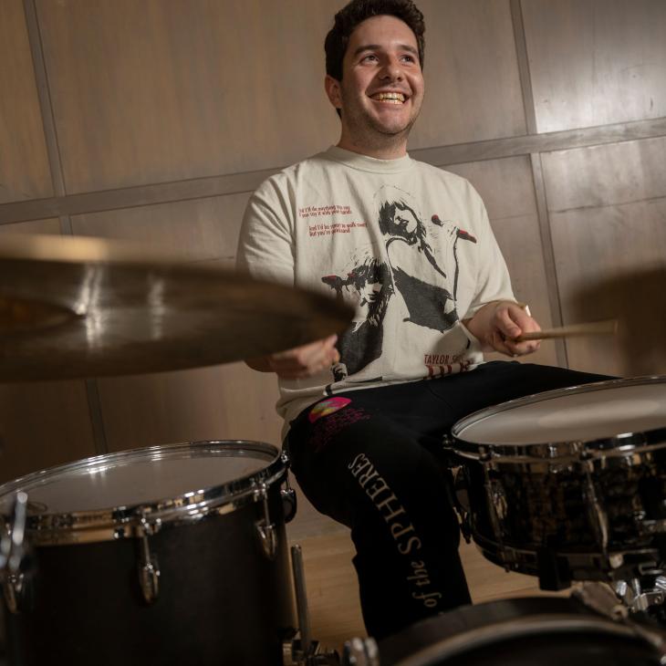 Music Student Smiling while playing the drums