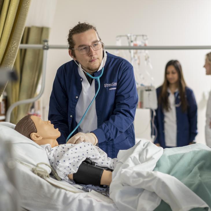 A student listening to their patient's heart rate.