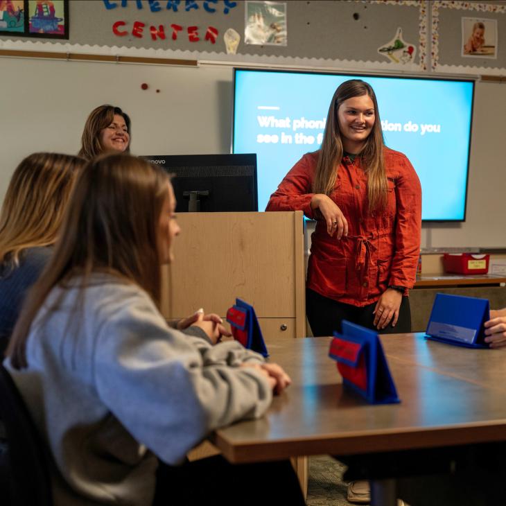 A student teacher in the classroom teaching.