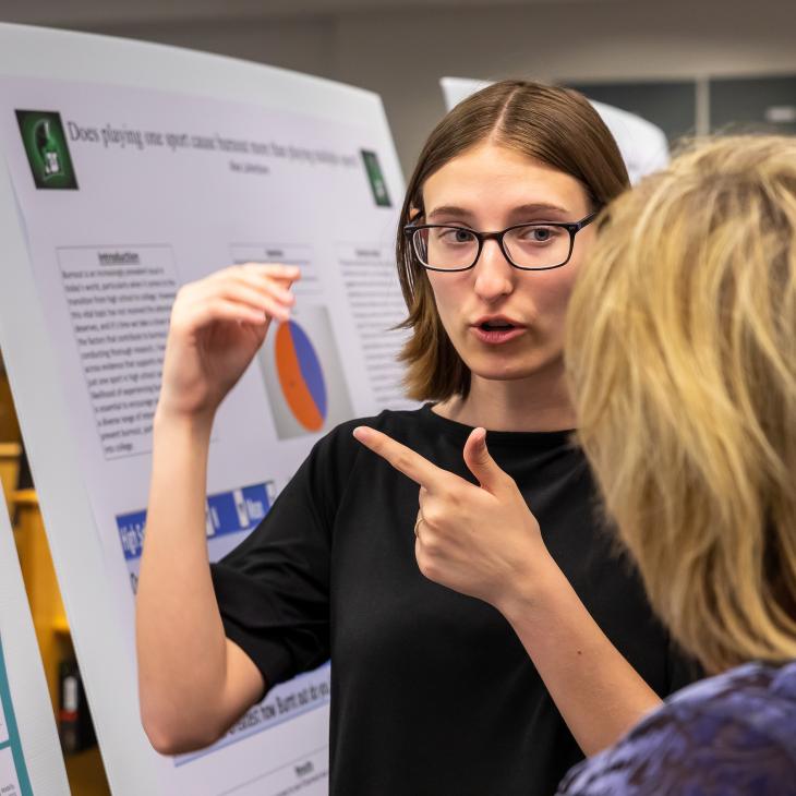 A student is explaining a visual aid they made