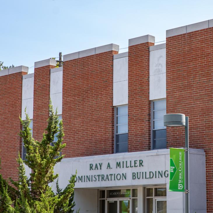 The brick facade and signage of the Ray A. Miller Administration Building