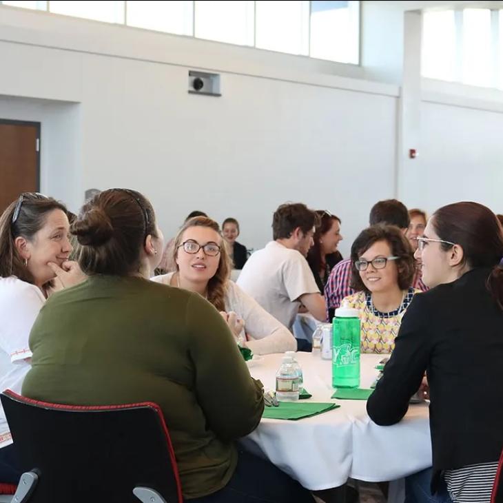 A group of students and a mentor sitting at a table in Yorkview Hall.