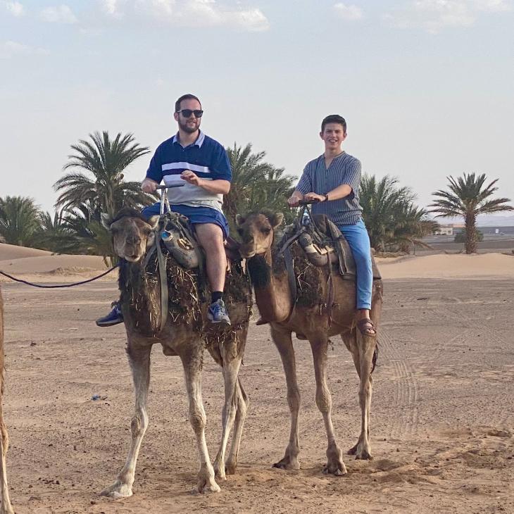 Students and faculty ride camels in the Moroccan desert.