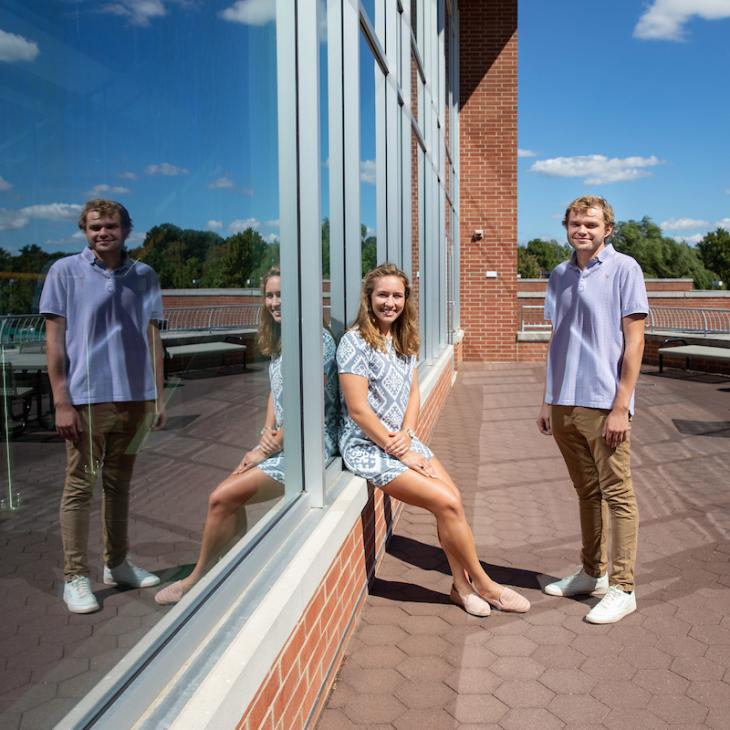 Two engaged scholars leaning against the WPAC window.
