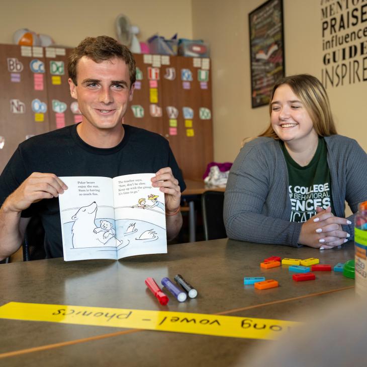 Students in an elementary classroom reading a children's book