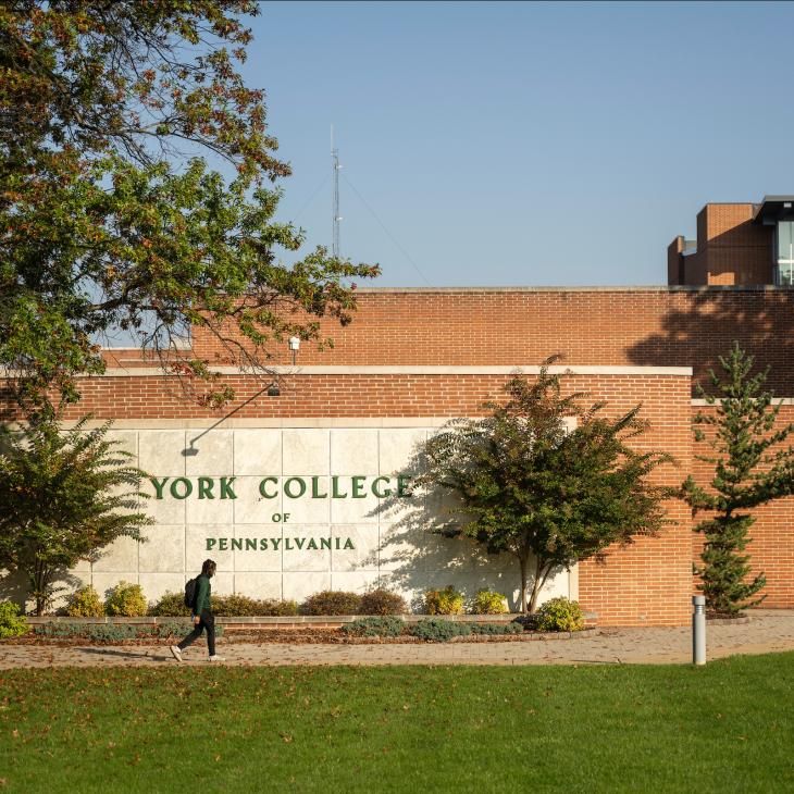 An exterior wall on the side of a brick academic building showcases built-in signage with the York College of Pennsylvania wordmark.