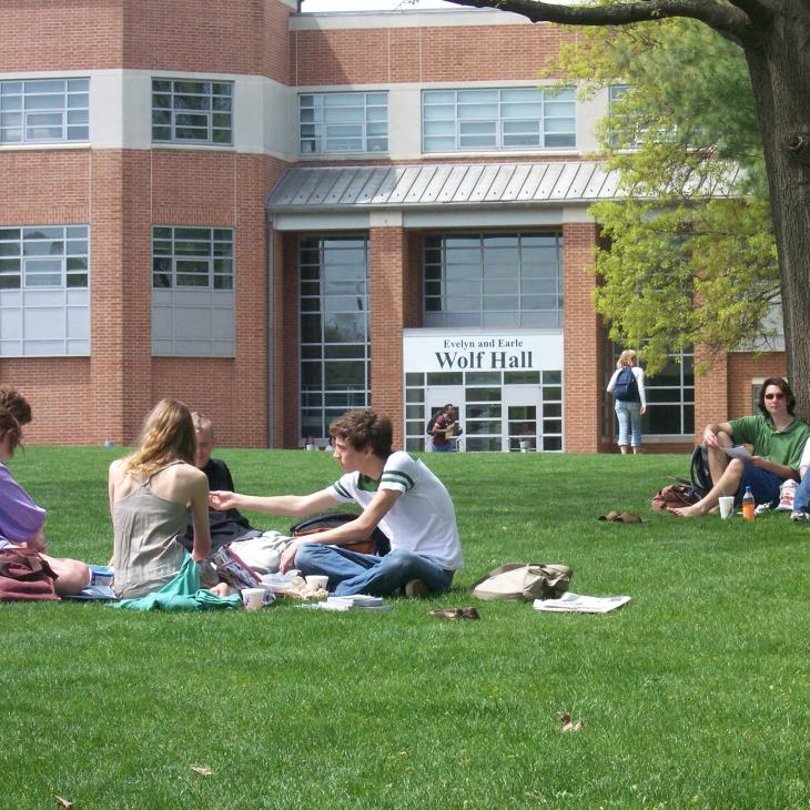 Students lounge on the lawn in front of Wolf Hall