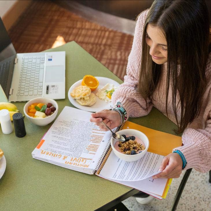 Student eating breakfast and studying at the West Campus Dining Hall