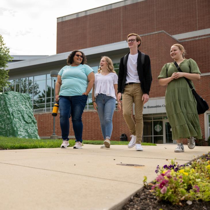 Group of students walking on campus near "the rock"