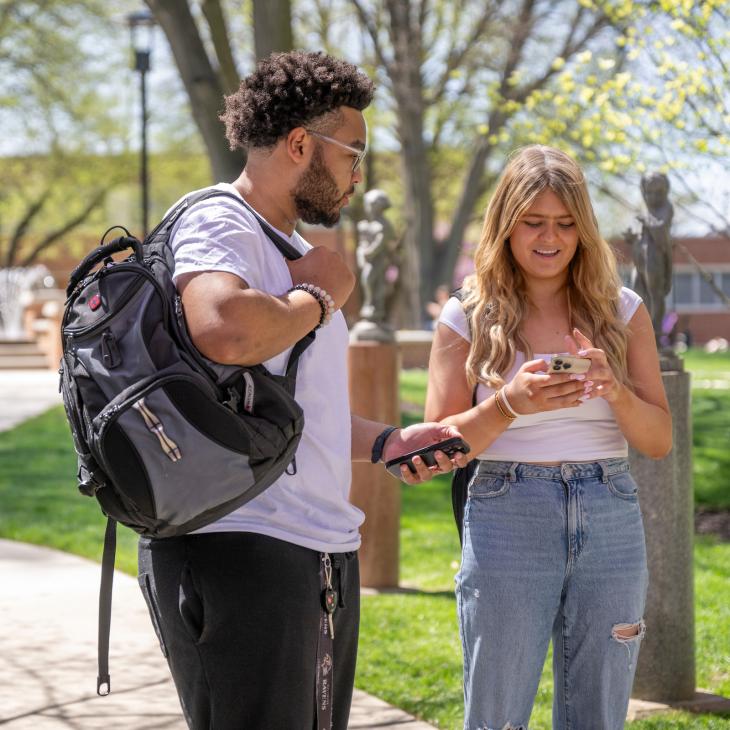 two students looking at cell phones