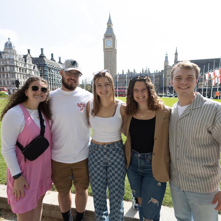 A group of five students pose for a photo, smiling with Big Ben in the background.