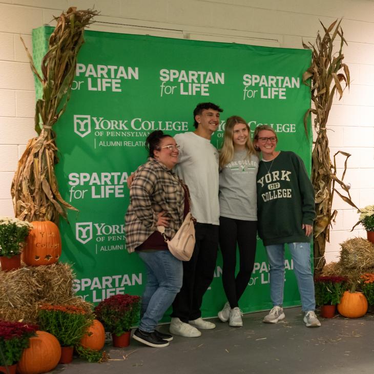 Four forever Spartans having their photo taken during Homecoming Weekend.