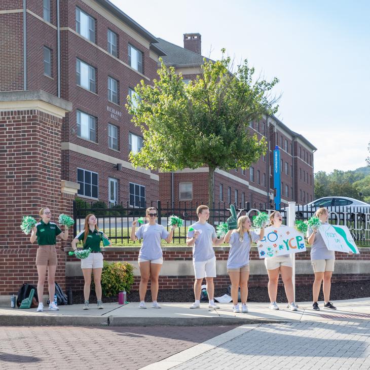 A group of students welcoming new students on move-in day in the fall.