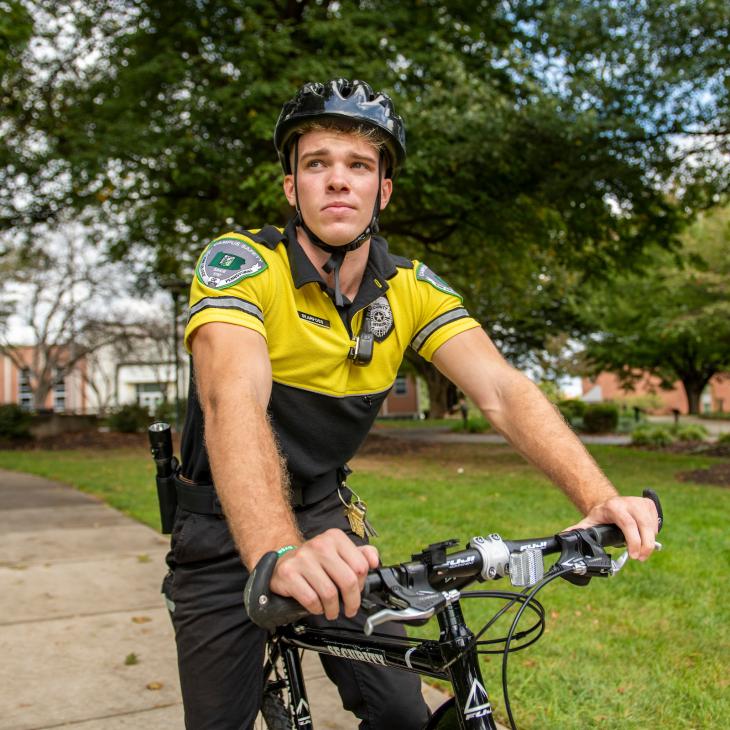 Campus Safety student worker on a bike on main campus.