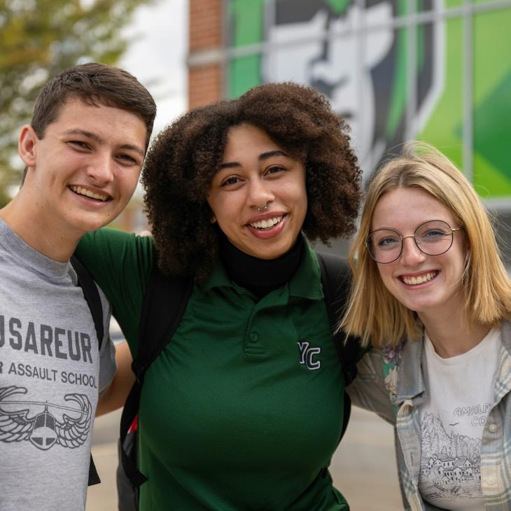 3 students in front of the Spartan Store smiling
