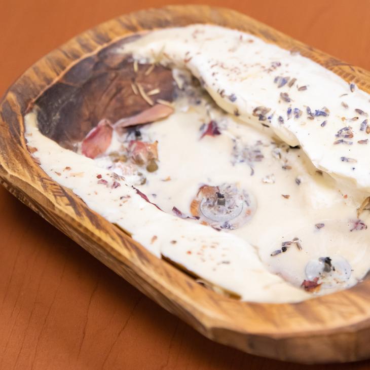 A small wooden bowl holds the remnants of a burnt-down candle