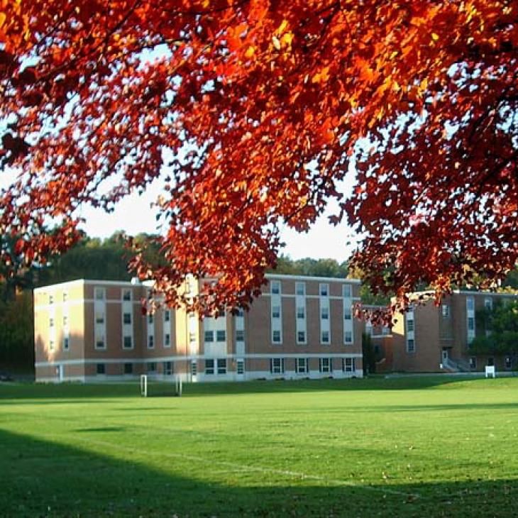 View of Manor Northeast from across a field with fall foliage.